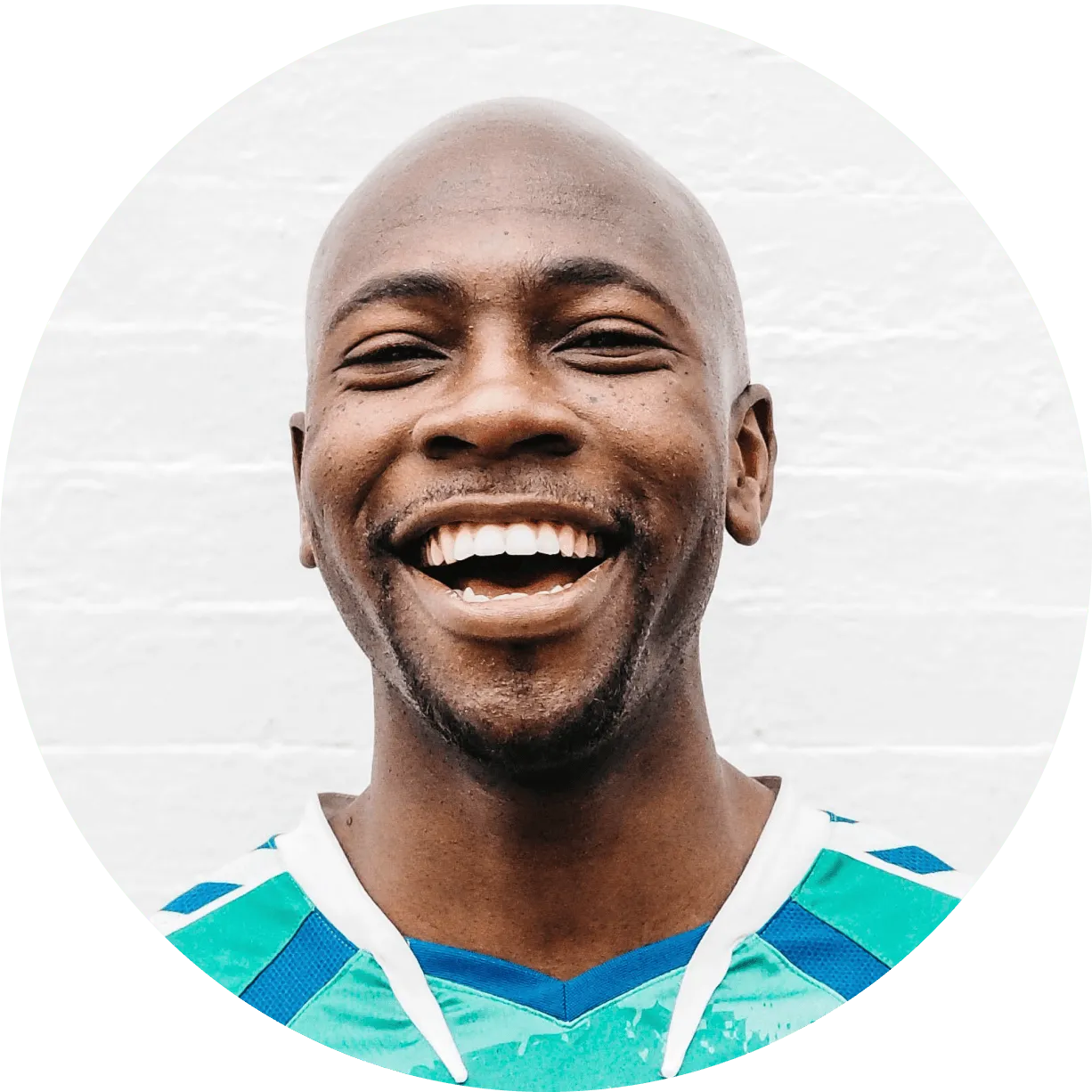 A smiling man in a blue and white shirt.